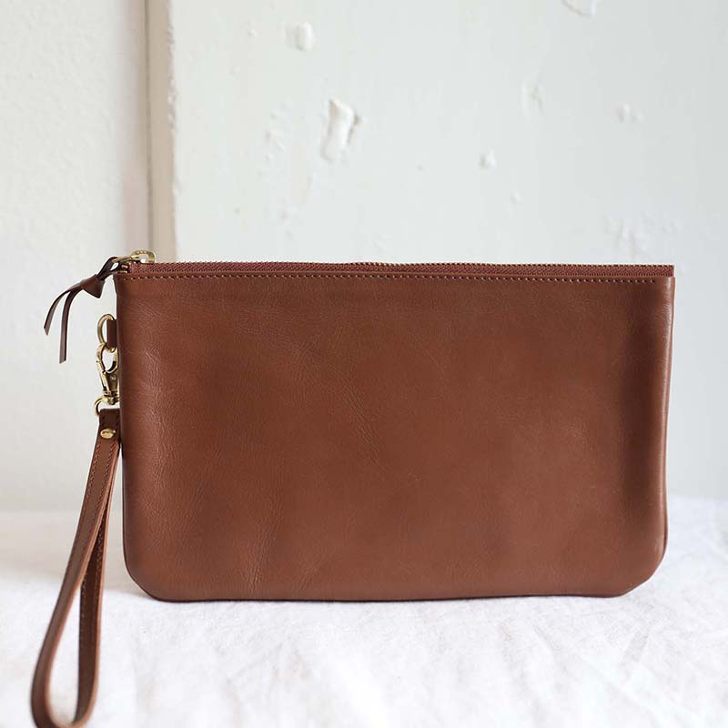 Tan wristlet clutch made from 100% natural leather and brass details with a zipper closure the perfect clutch for your everyday essentials