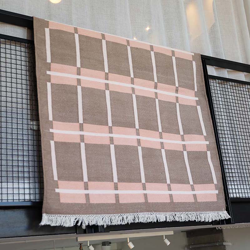Pink toned rug with brown and white square patterns handwoven on wooden loom by Banskhon artists for Bloom & Give