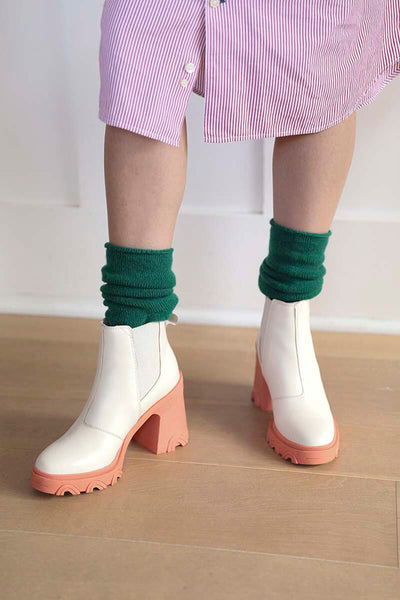 Emerald green cashmere socks ethically made in Zhangjiagang from Mongolian cashmere for Joyride Supply. Styled here with white and pink block heeled raincoats.