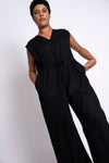 Model wears black linen jumpsuit made from linen stretch blend.