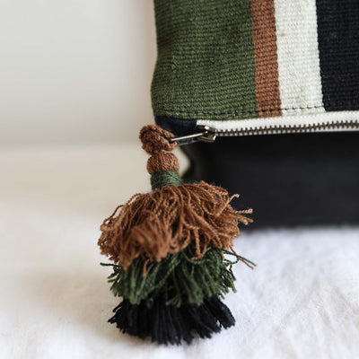 Close up shot of pom pom tassel detail with upcycled thread in brown, olive green and black