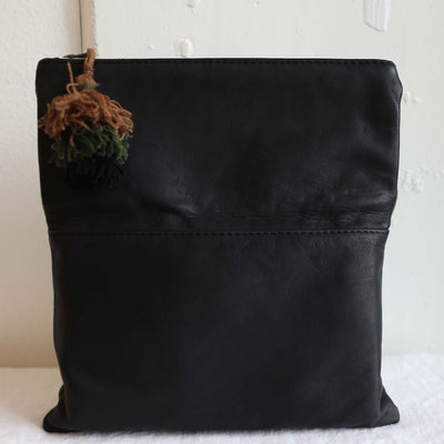 Back side of clutch created with Peruvian leather brown green black pom pom tassle