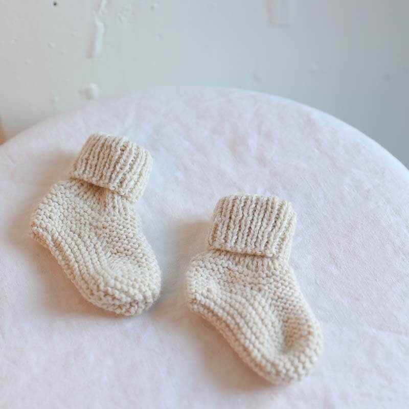 White Muku Booties for ages 6-12months old hand knitted from baby alpaca yarn and pima cotton by artisans for Awamaki in Peru