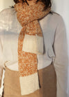 Detail shot of the Awamaki Pampa Scarf knotted around neck showcasing beautiful handwoven details of knitwear