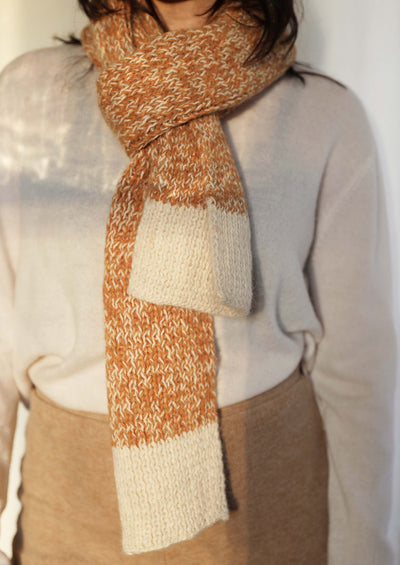 Detail shot of the Awamaki Pampa Scarf knotted around neck showcasing beautiful handwoven details of knitwear