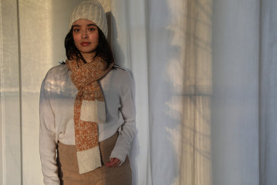 Model wears the Awamaki Pampa Scarf in daffodil color for The Cura Co paired with the cream Awamaki Pampa Cap