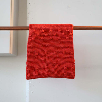 The Wayra Infinity Scarf in a red poppy color ethically handmade by Peruvian artisans for Awamaki