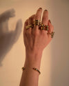 Artisan made chunky wrap ring by Bawa Hope on left pointer finger layered on models hand mixed with other Bawa Hope Rings