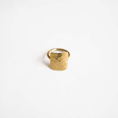 An organically shaped brass square cast ring with raw molten textures on the surface