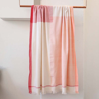 Handwoven pink and white cotton blanket crafted in a traditional wooden loom