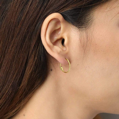 Model wears a hoop earring made from 14k gold vermeil by asian owned brand Boma Jewelry sustainably handcrafted
