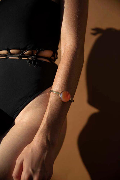 Corset detail with a string to adjust or cinch. Show off a little midsection and high cut legline in this swimsuit paired here with a Cura Banging Stone Cuff in the Carnelian stone