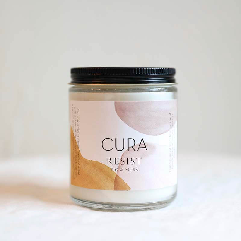 Resist candle by Cura Co and Prosperity Candles ethically handpoured in a 10oz glass vessel notes of fig and musk  Edit alt text