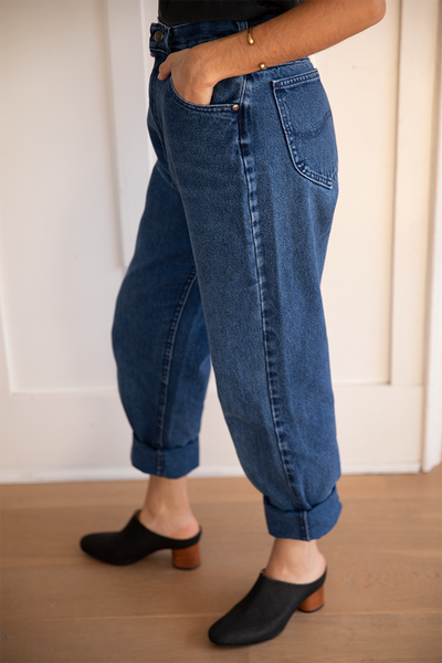 Side view of the vintage dark blue lee denim paired with black slide mules with a wooden block heel