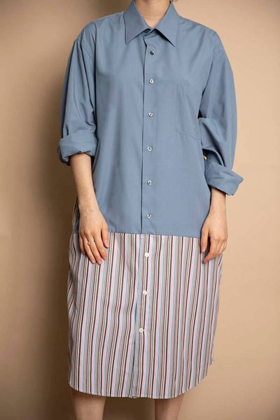 Colorblock design from two mens button up collared blouses. The top portion is a light faded blue, drop waist fit with pink, purple and grey pinstripe pattern. Dress hits below the knee.