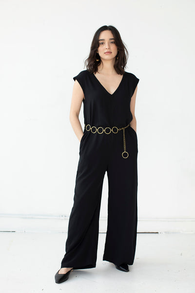 Cristina wears the Domoto jumpsuit by Cura in black with gold hoop belt. Ethically made in Cambodia