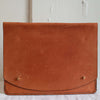 Tan leather portfolio or laptop case ethically made by Haiti Design Co with brass closures