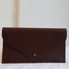 Ethically made chestnut leather rectangle clutch with fold over flap and brass closure