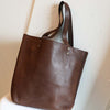 Brown vegetable tanned leather tote with shoulder straps and solid brass details ethically made by Haiti Design Co