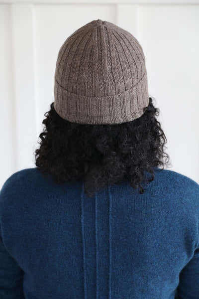Back of the cashmere ribbed beanie cuffed on model, ethically made by Joyride Supply