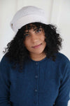 White slouchy beanie knit in a ribbed stitch with a slightly curled edge. Made with 100% Mongolian Cashmere