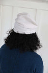 White slouchy beanie back view. Ribbed stitched, worn folded at bottom.