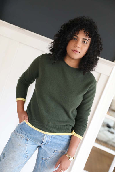 Jayne cashmere crewneck in solid green  features a yellow trim on the sleeves and bottom hem of sweater. Round neckline. Ethically made from grade a Mongolian cashmere.