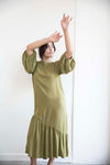 Sophia wears the Olive green Masako Midi dress with bracelet length sleeve, asymmetrical rushed hem detai part of the Hanae Collection by The Cura Co