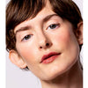 Shot hair fair skinned model wears the Five multi bene stick on her lips and cheeks appears a reddish pink on her skin.