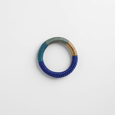 Handbraided rope bracelet in indigo blue, teal, and gold. Embellished with wax cotton and gold lurex thread. Ethically made in Cape Town, South Africa.