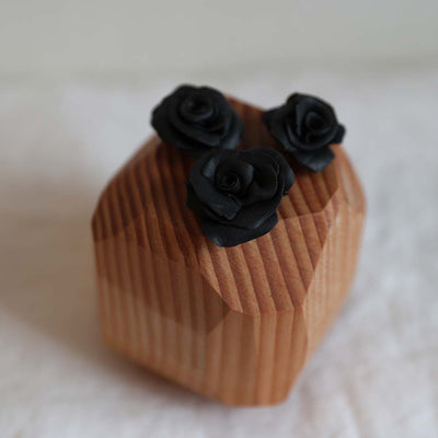 Hand sculpted polymer resin and upcycled hardwood sculpture by Theresa Wingert with three black roses ethically made in Seattle Wa