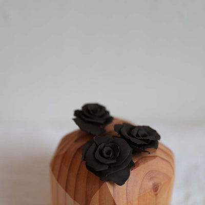 Three brown roses handmade from polymer resin by local Seattle artist Theresa Wingert founder of Sound Yard