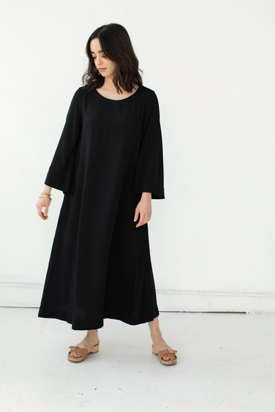 Model sways while wearing Tomoko Bell Sleeve midi dress in black