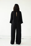 Back view of Cristina wearing the black Tomoko Jumpsuit part of the Hanae Collection by The Cura Co