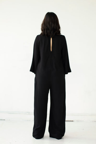 Back view of Cristina wearing the black Tomoko Jumpsuit part of the Hanae Collection by The Cura Co